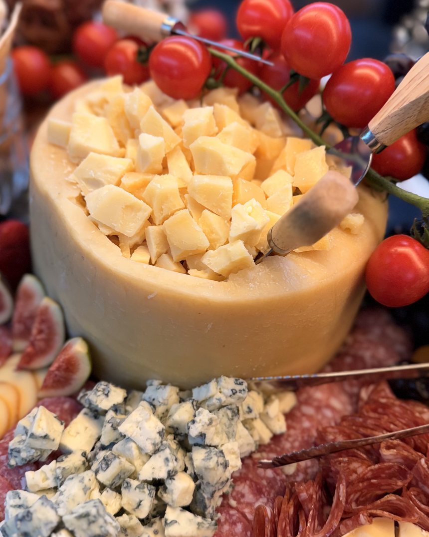 Queijo servido dentro da casca com tomate e copa